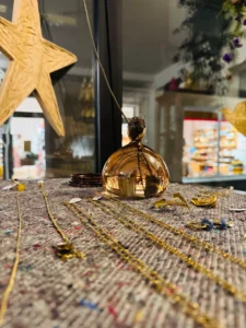 Eichel Vase in Apricot auf einem schwebenden Regal. Darauf befinden sich auch mehrere Schmuckstücke.